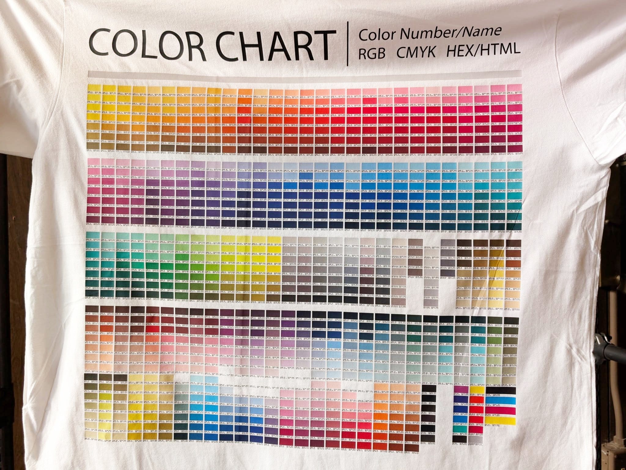 White t-shirt with a color chart printed on it.